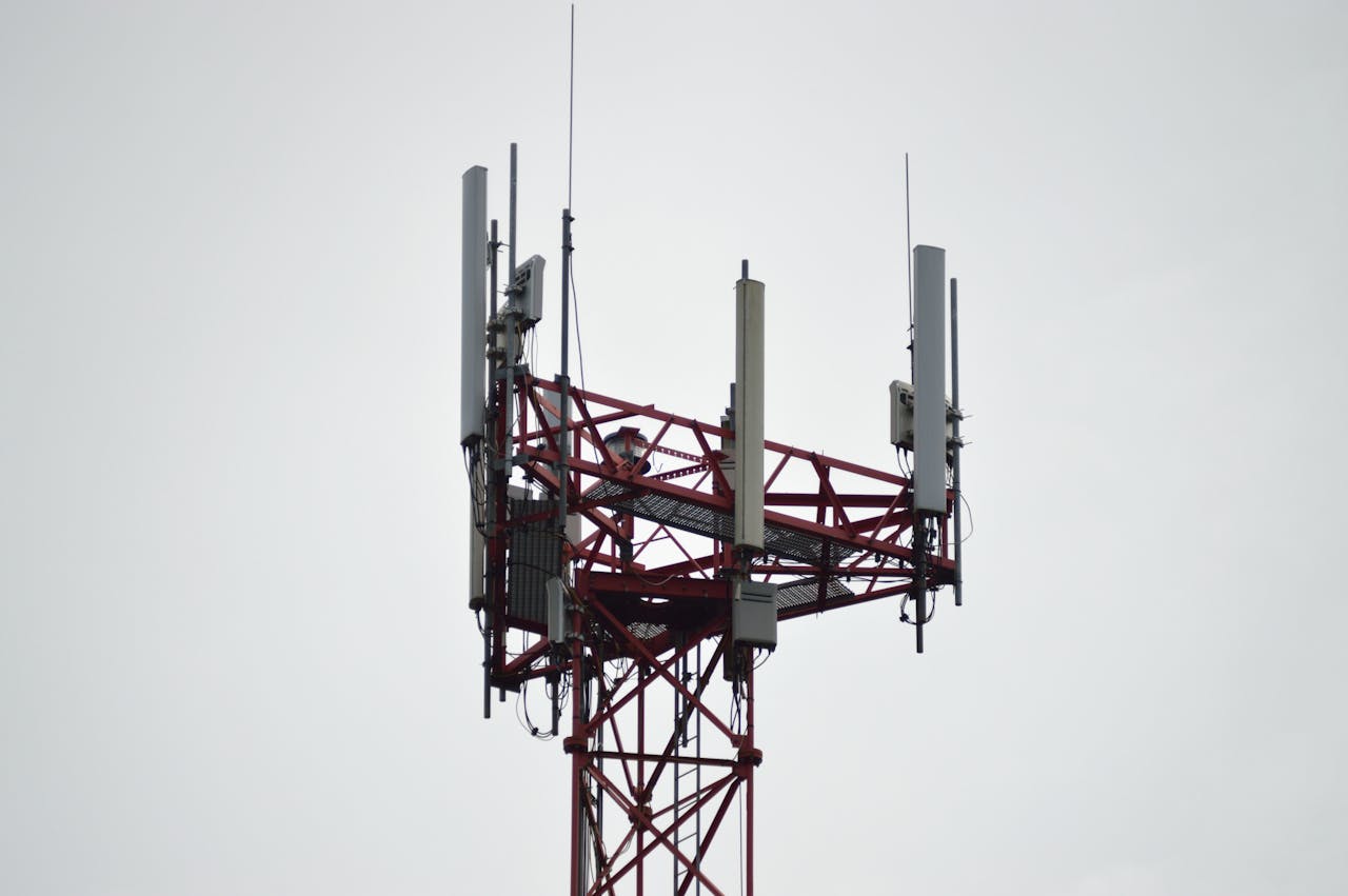 why-choose-us A red communication tower with antennas stands tall against a gray sky.